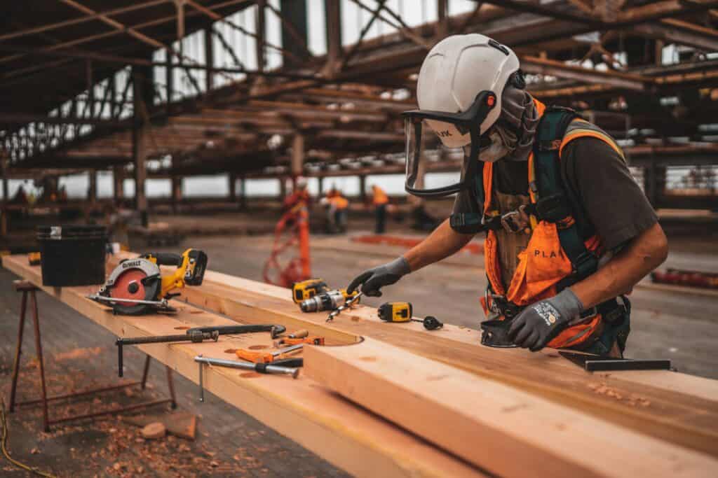 Charpentier travaillant une poutre en bois massif en atelier